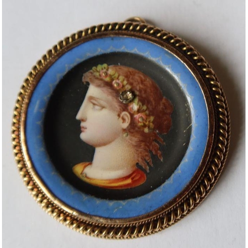 455 - A Victorian circular enamel brooch, decorated with a portrait, set with a gem stone, diameter 1.5ins... 