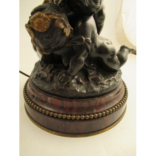 490 - A Bronze and gilt mounted table lamp formed as Putti holding a basket raised on a beaded marble base... 