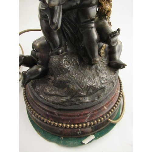 490 - A Bronze and gilt mounted table lamp formed as Putti holding a basket raised on a beaded marble base... 