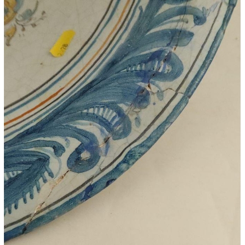 529 - A Spanish pottery bowl, decorated to the centre with a helmet on a bridge with building and scrolls,... 