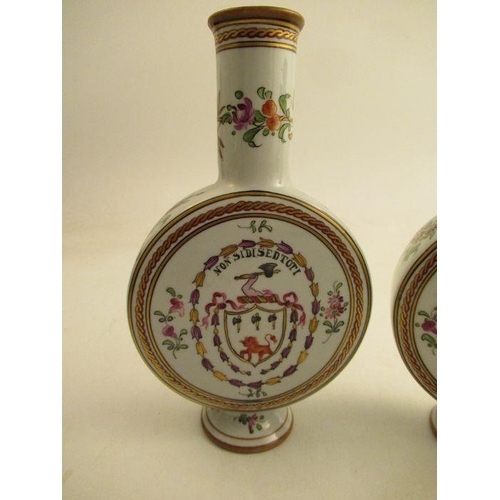 536 - A pair of continental style moon flasks, decorated with armorial and foliage. height 8ins