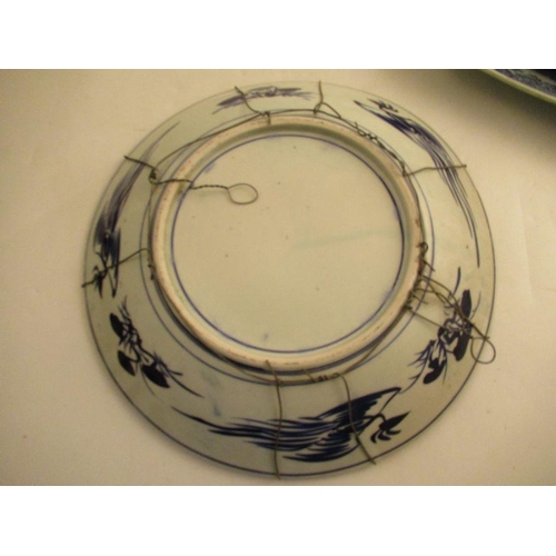 540 - An 18th century Chinese blue and white charger badly AF, together with a dish, a plate decorated wit... 