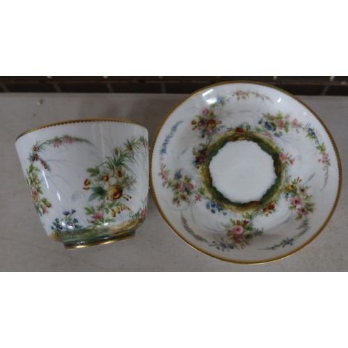 561 - A Minton cabinet cup and saucer, decorated with flowers within a gilt border, impressed mark