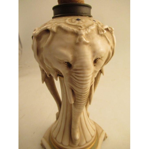 570 - A continental porcelain oil lamp base, modelled as three elephant heads, af, height 10ins