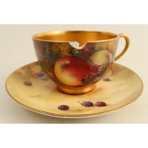 580 - A Royal Worcester cup and saucer, the exterior of the cup and the saucer decorated with fruit to a m... 