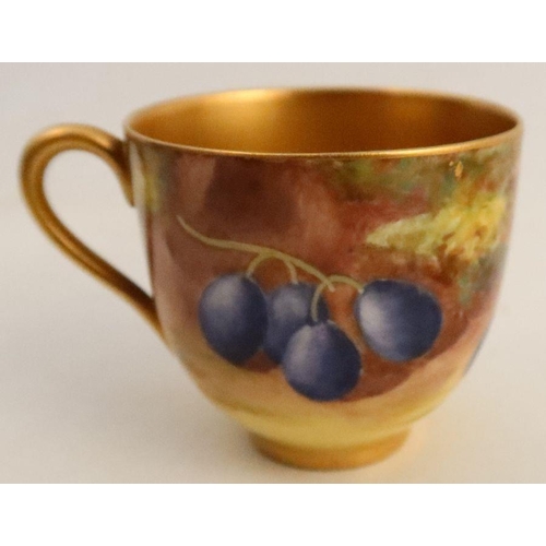 584 - A Royal Worcester cup and saucer, the exterior of the cup and the saucer decorated with fruit to a m... 