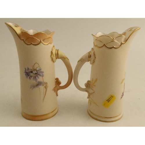 602 - Two Royal Worcester jugs, decorated with flowers to ivory ground, one with blush ivory to rim, handl... 