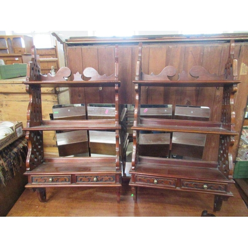 23 - A pair of mahogany wall shelves, with pierced shaped sides, fitted with two small drawers, height 37... 