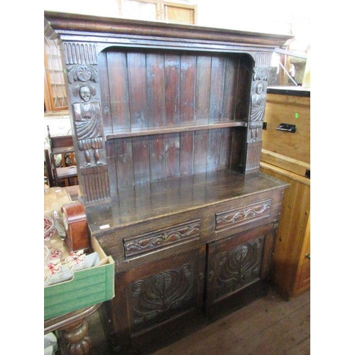 30 - An antique style oak dresser the upper section with carved figures width 46ins height 67