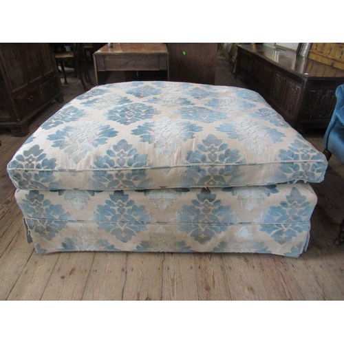 61 - A large upholstered salon stool or pouffe, with floral covering, approximately 48ins x 36ins