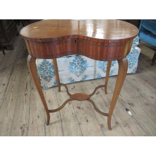 65 - An Edwardian satinwood kidney shaped work table, having a rising lid to reveal fitted compartments, ... 