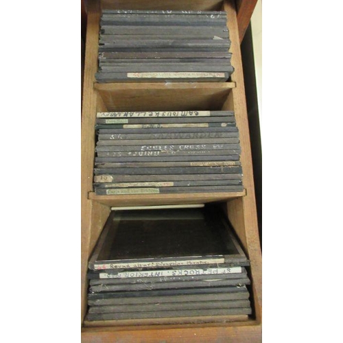 173 - A wooden four drawer filing box, containing a collection of glass magic lantern slides