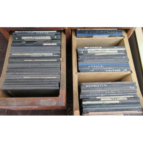 173 - A wooden four drawer filing box, containing a collection of glass magic lantern slides