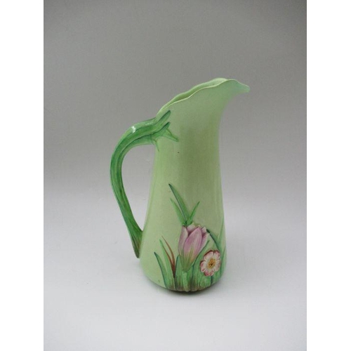 176 - A Carlton Ware green ground jug, decorated with relief irises and flowers, height 8.5ins