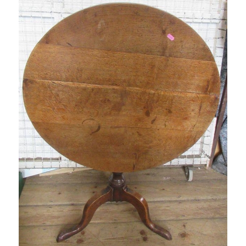 48 - An Antique oak tripod table, raised on a turned column with three outswept supports, diameter 29.5in... 