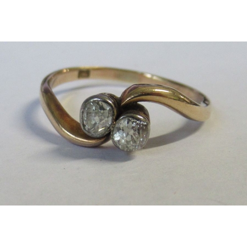 316 - A two stone cross-over diamond ring, total diamond weight estimated 0.25ct. weight 2.2g , small chip... 