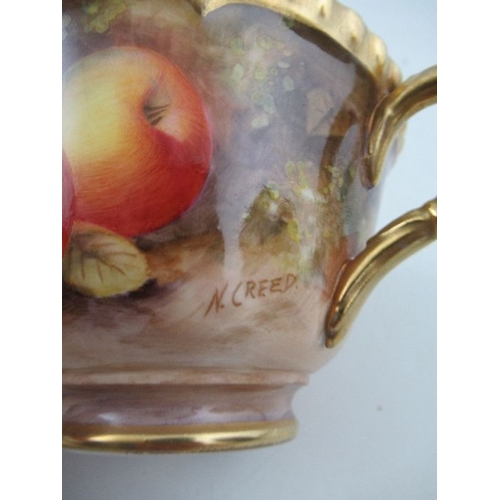 383 - A Royal Worcester cabinet cup and saucer, decorated with hand painted fruit, signed N.Creed