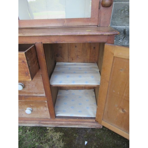 56 - A pine cupboard the upper section having two glazed doors over cupboards and drawers to the base  (2... 