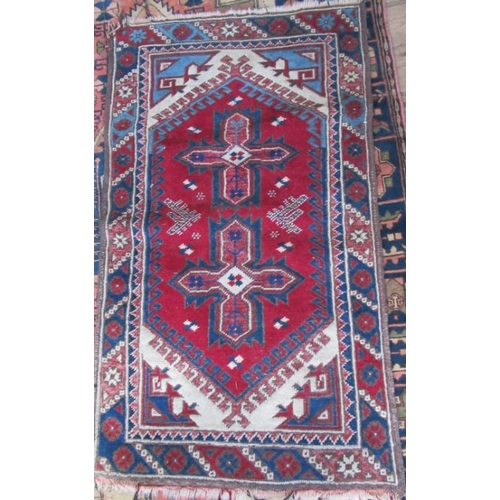 73 - An Eastern design rug, decorated with hooked motifs, in red, blue and white, 53ins x 31ins