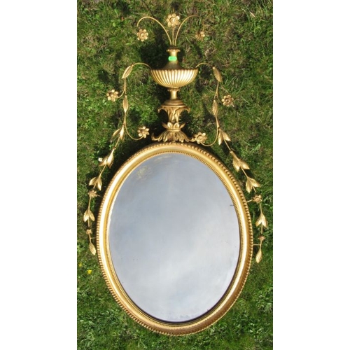 83 - A gilt framed wall mirror, with urn and flower decoration