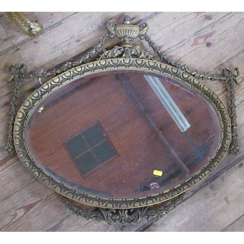 84 - A oval gilt framed wall mirror with urn, swag and ribbon decoration