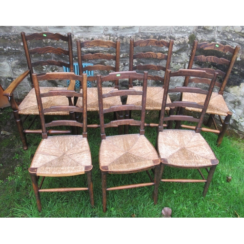 42 - A set of four (3+1) oak ladder back chairs, with rush seats, together with another set of three