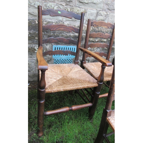 42 - A set of four (3+1) oak ladder back chairs, with rush seats, together with another set of three