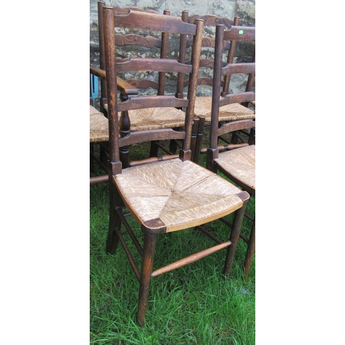 42 - A set of four (3+1) oak ladder back chairs, with rush seats, together with another set of three