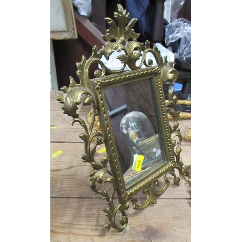 105 - A pair of mirrors, in gilt metal scroll frames with easel back, overall 11ins x 9ins, together with ... 