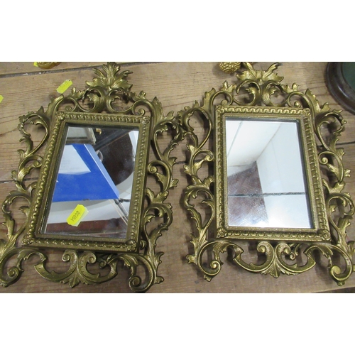 105 - A pair of mirrors, in gilt metal scroll frames with easel back, overall 11ins x 9ins, together with ... 