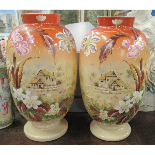 238 - A pair of Edwardian glass vases, decorated with houses, height 13ins