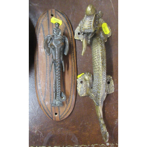 239 - A brass door handle, modelled as a dragon, together with a door knocker modelled as an elephant