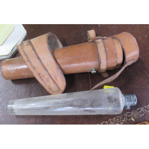 240 - A hunting conical shaped glass flask, with leather case and fittings to attach to a saddle