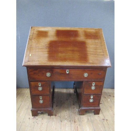 48 - A 19th century mahogany desk, having raising top with ratcheted support, the drawer opening to revea... 