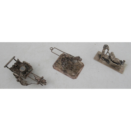 221 - Three Dutch silver miniature models, figures pushed in a sledge, cart pulled by a dog with figure an... 