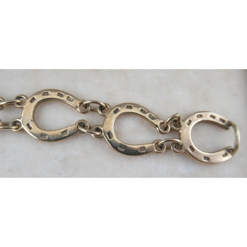 239 - A 9ct gold bracelet, made up of horseshoes joined by chains, marked 375, weight 9.5g, in a Garrard a... 