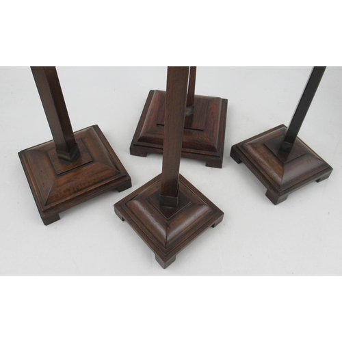 24 - A set of four early 20th century oak and mahogany graduate shop fitting hat display stands, by Harri... 