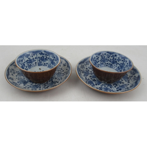 265 - Two Chinese porcelain café au lait tea bowls and saucers, decorated with blue and white flowers