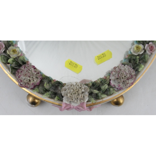 274 - A Continental porcelain encrusted oval mirror, decorated with putti and flowers, with easel support,... 