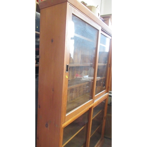 36 - A pine double bookcase, with sliding glazed doors and adjustable shelves, height 78ins, width 50ins,... 