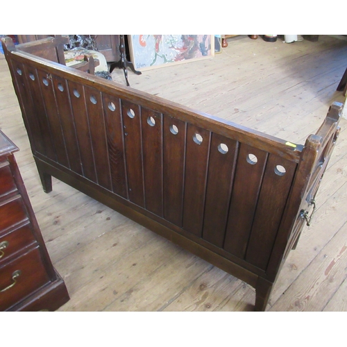 6 - An Arts and Crafts style child's oak settle, with carrying handles and supports in the gothic style,... 