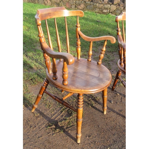 7 - A pair of Windsor arm spindle back arm chairs, with a round seat, raised on turned legs united by H ... 