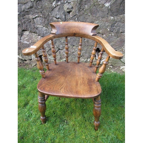 An elm captains chair, with turned spindle back