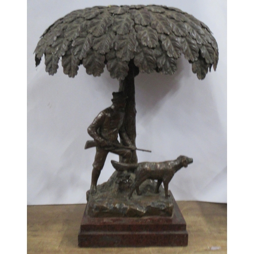 165 - A pressed metal table lamp, formed as a huntsman carrying a gun with hound, under a tree, height 15i... 