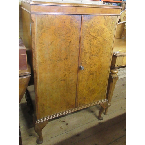 40 - A Wilson & Gill London walnut veneered drinks cabinet, with hinged rising lid, over a pair of doors ... 