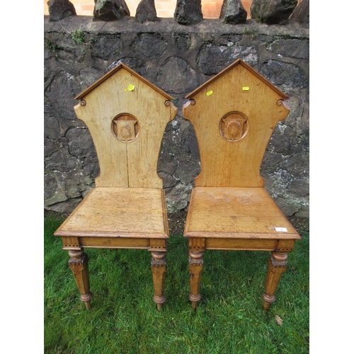 6 - A pair of 19th century oak hall chairs, with shield to the carved solid back, solid seat, on inlaid ... 