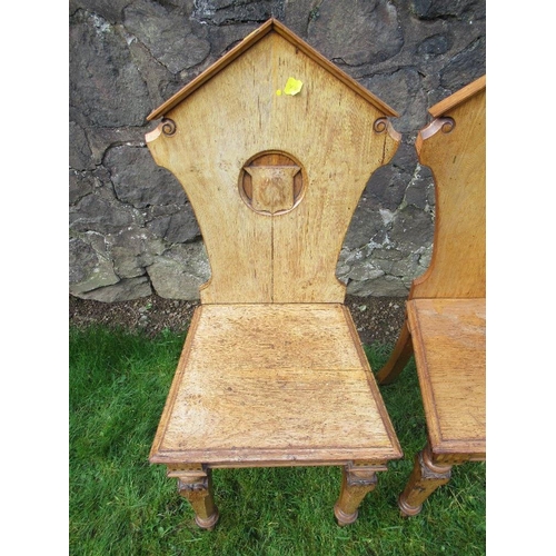 6 - A pair of 19th century oak hall chairs, with shield to the carved solid back, solid seat, on inlaid ... 