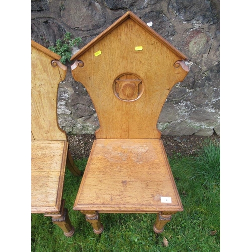 6 - A pair of 19th century oak hall chairs, with shield to the carved solid back, solid seat, on inlaid ... 