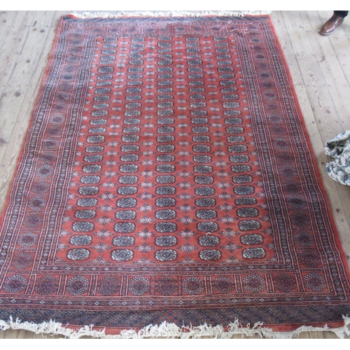 87 - An Eastern design rug, the field with repeating motifs and a red ground, 101ins x 73ins