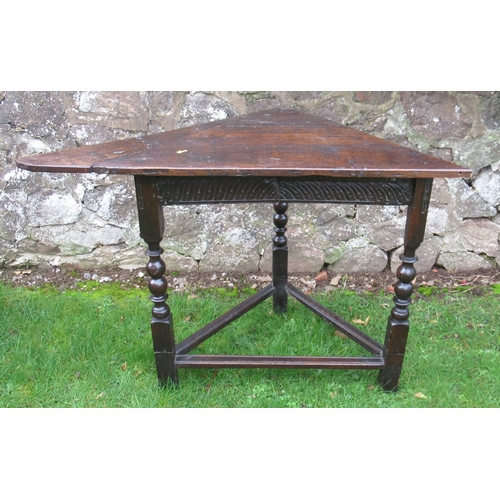 28 - An Antique oak corner table, of triangular form, 43ins x 25ins, height 30ins